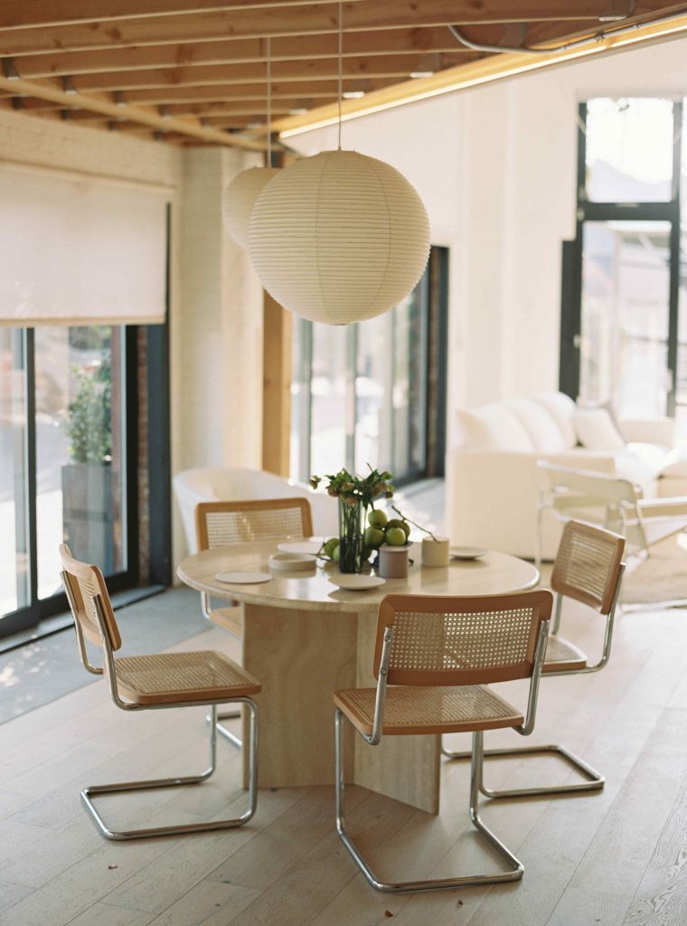 Jedálenský stôl s pletenými stoličkami a papierovým svietidlom