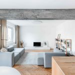 Obývačka se šedou pohovkou a betónovým pilierom