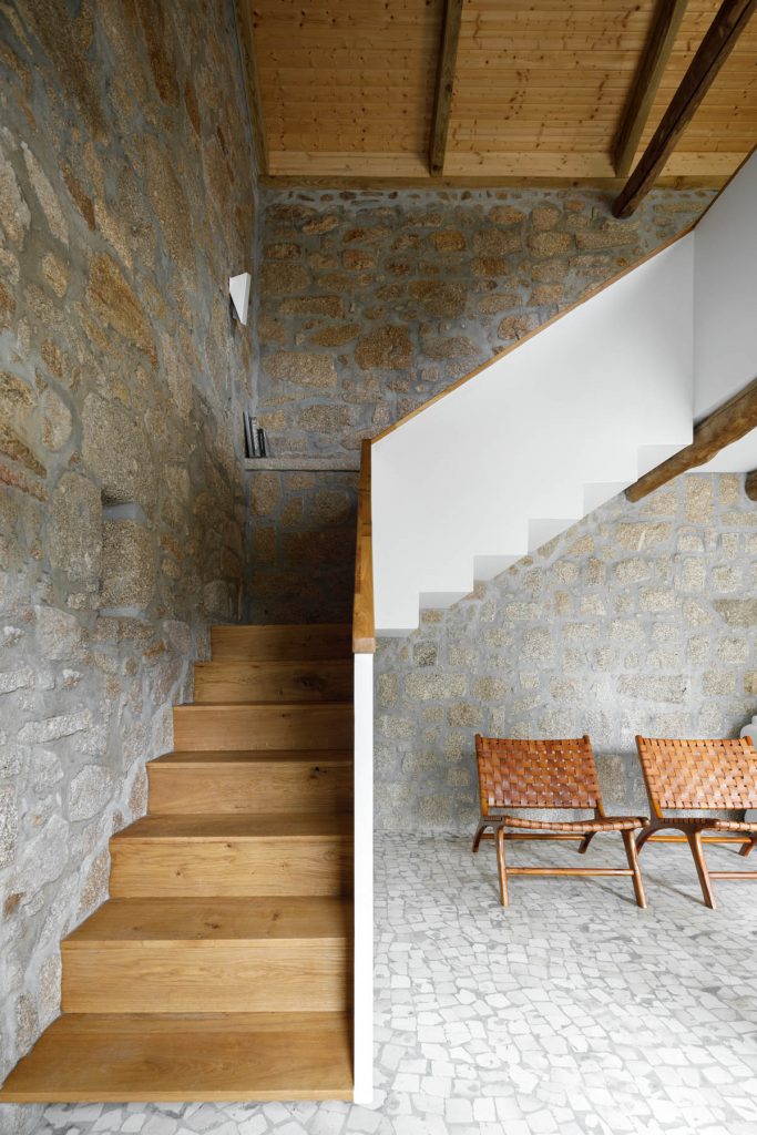Drevené schody s vonkajšej strany biele v kamennom interiéri