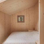 Spálňa v svetlom dreve v podkroví chaty