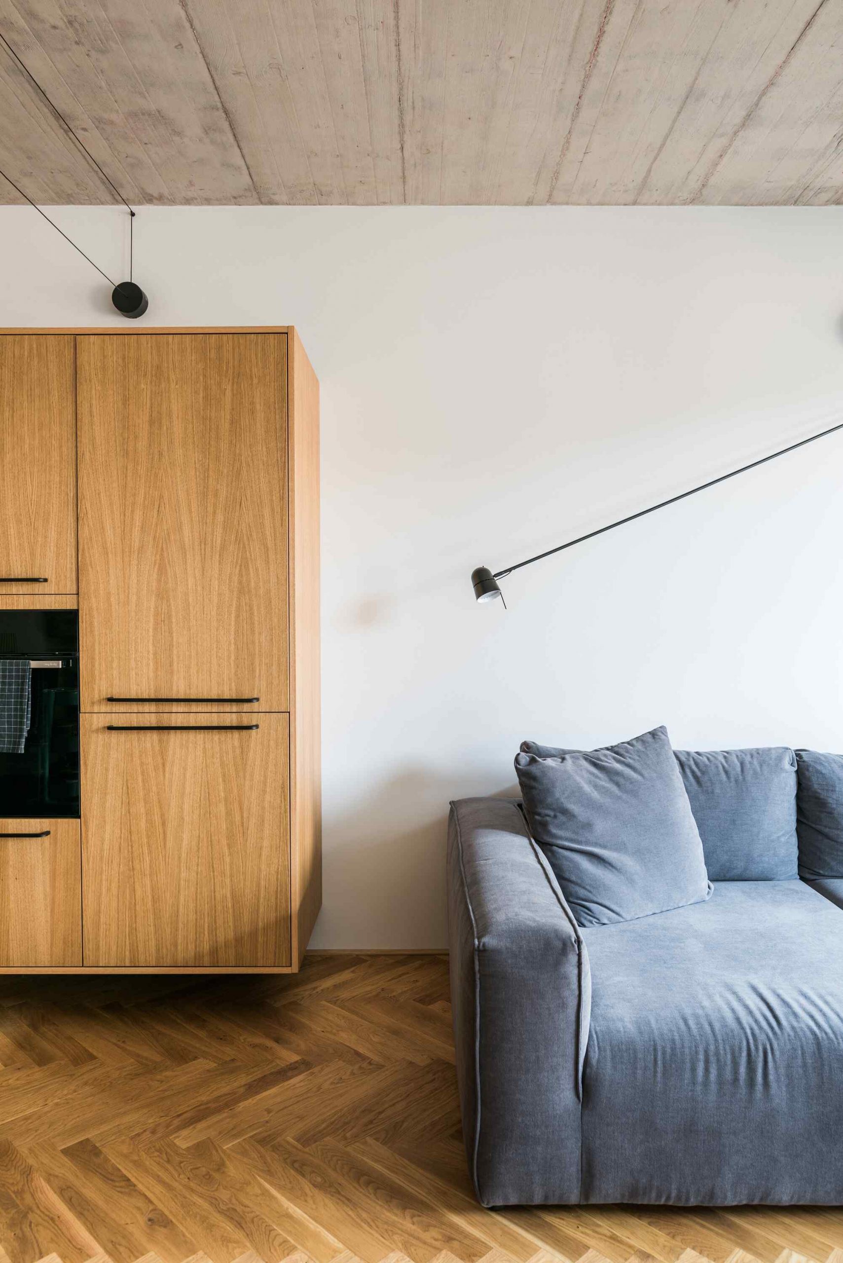 Čierno – bielo – hnedá kombinácia vytvára príjemnú atmosféru, ktorú zmäkčuje kresba dreva.