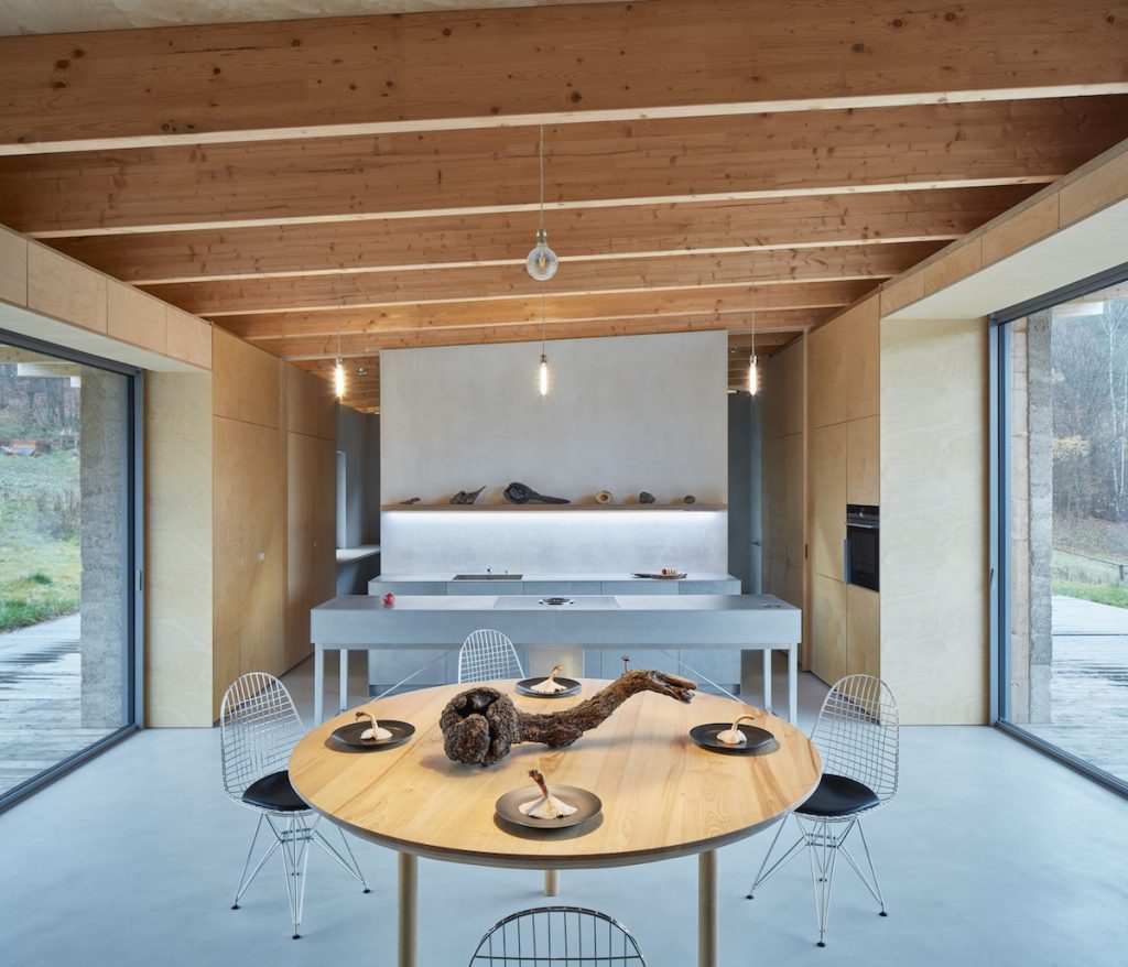 Sivá kuchyňa a jedáleň v drevenom interiéri