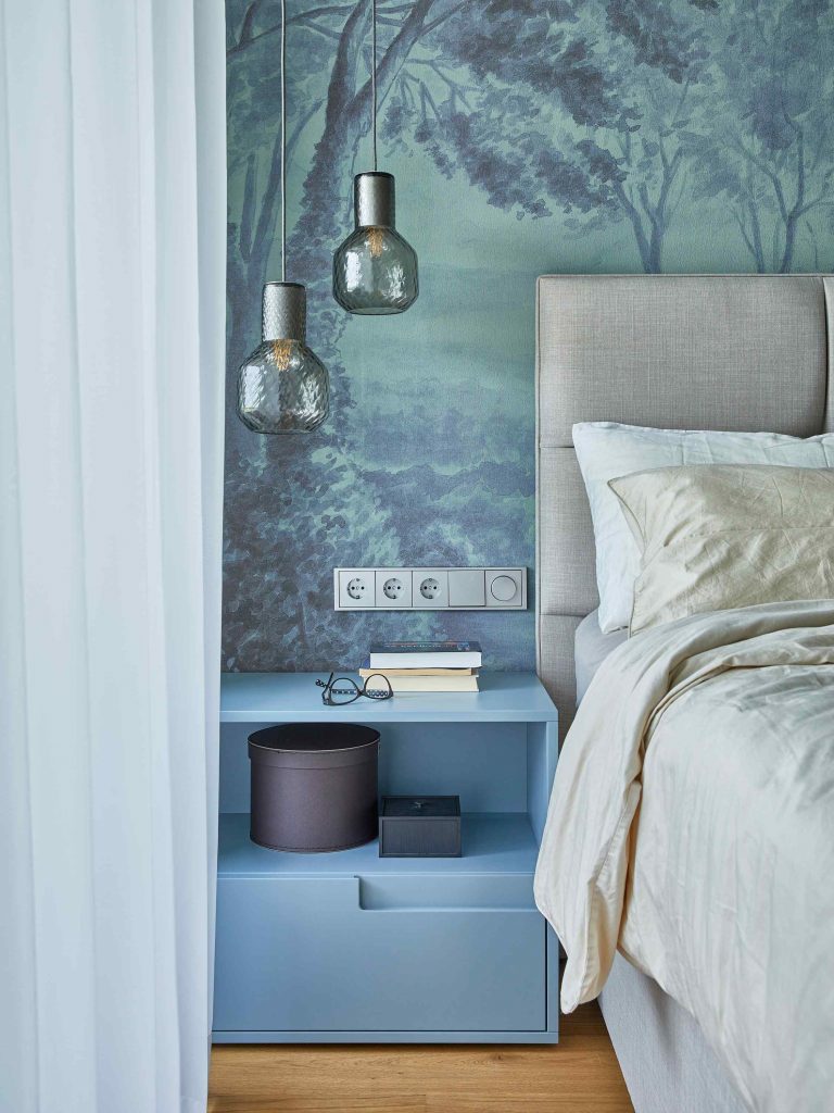Modrá spálňa s dizajnovým svietidlom