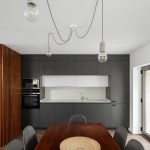 Sivá kuchyňa s drevenou stenou a jedálňou