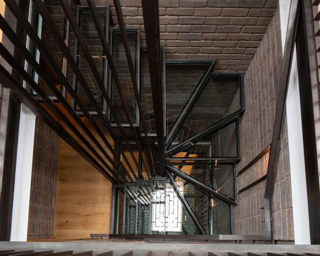 Kovové schodisko s tehlovou stenou