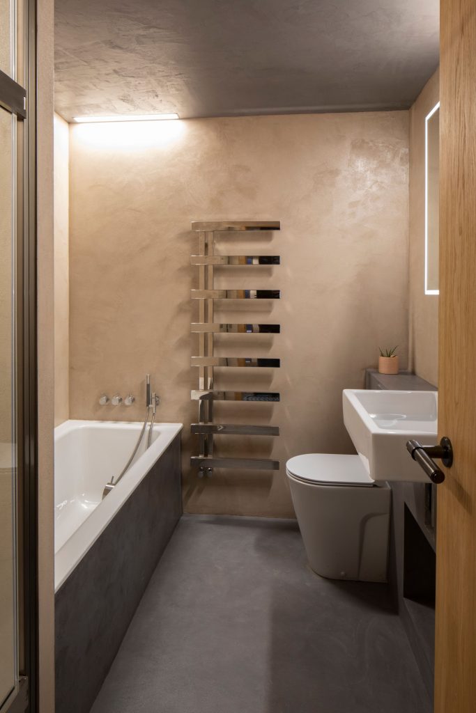 Kúpeľňa v hnedej a sivej s dizajnovým radiátorom