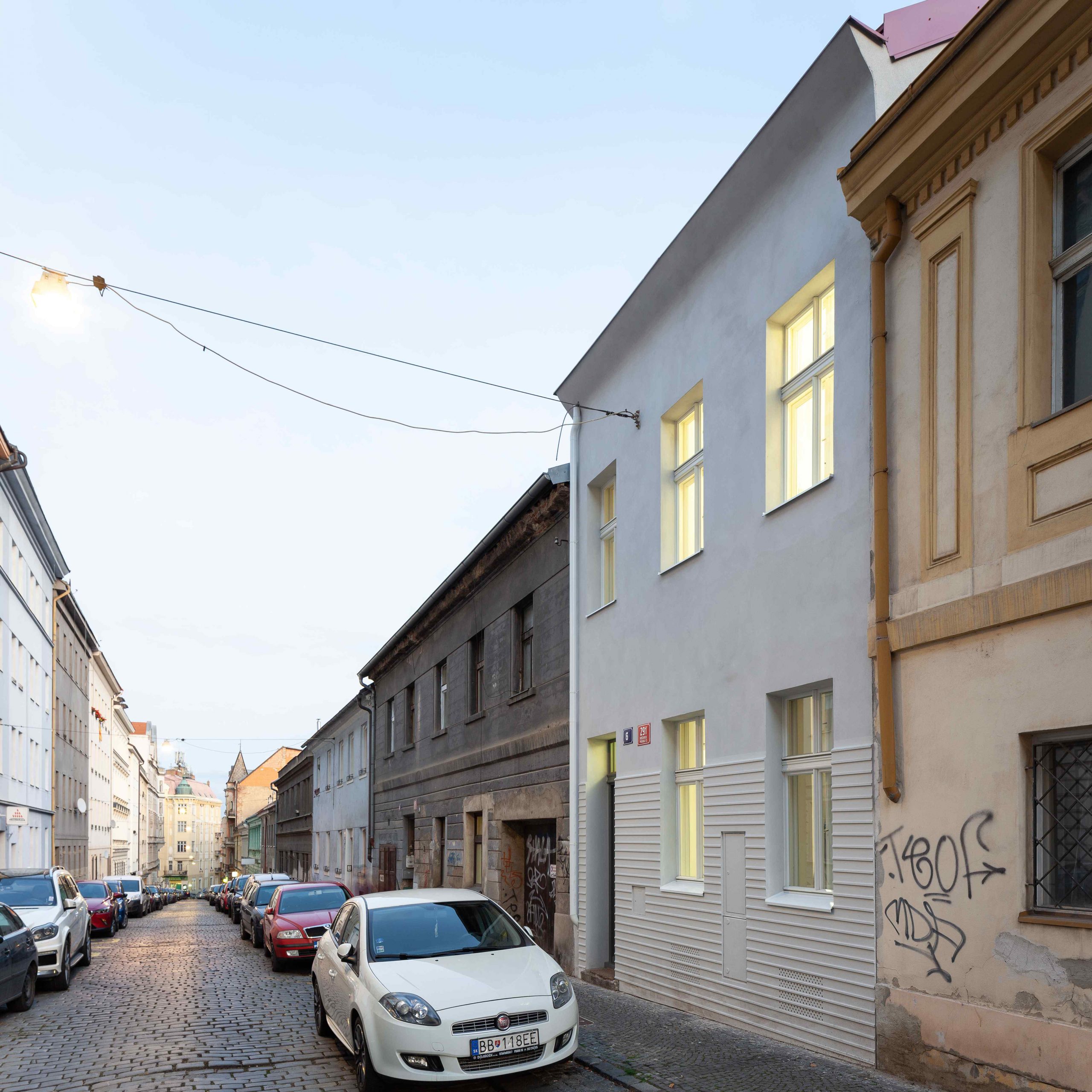 Starší biely zrekonštruovaný trojpodlažný dom v Prahe