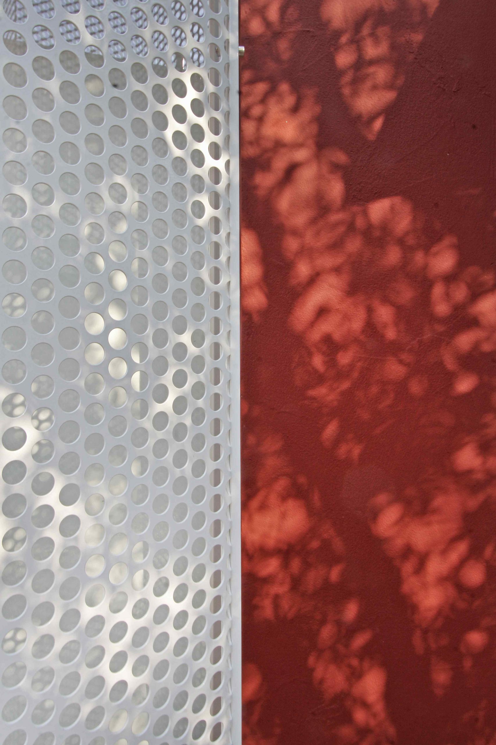 Detail dierovanej kovovej mriežky. 