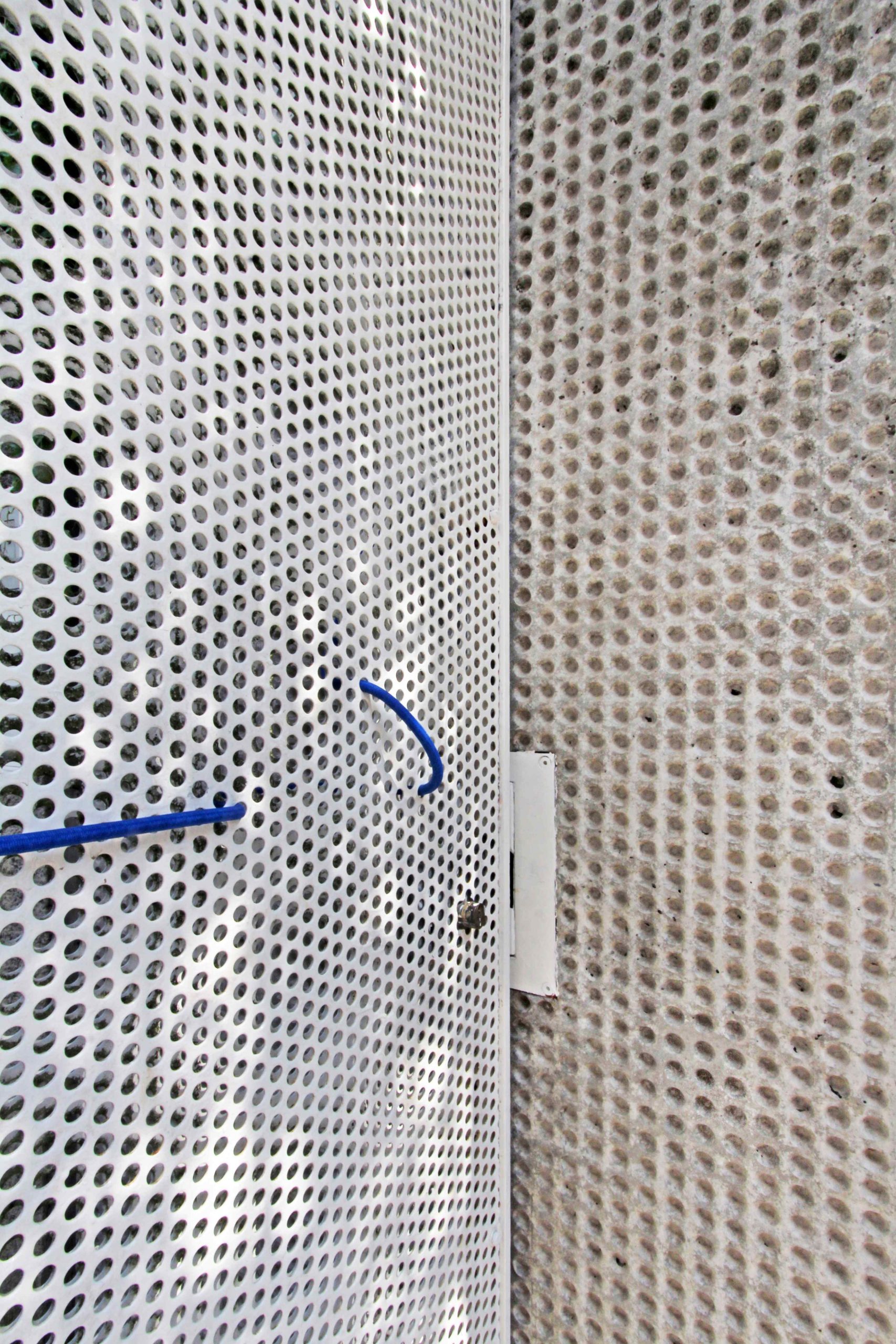 Detail dierovanej kovovej mriežky. 