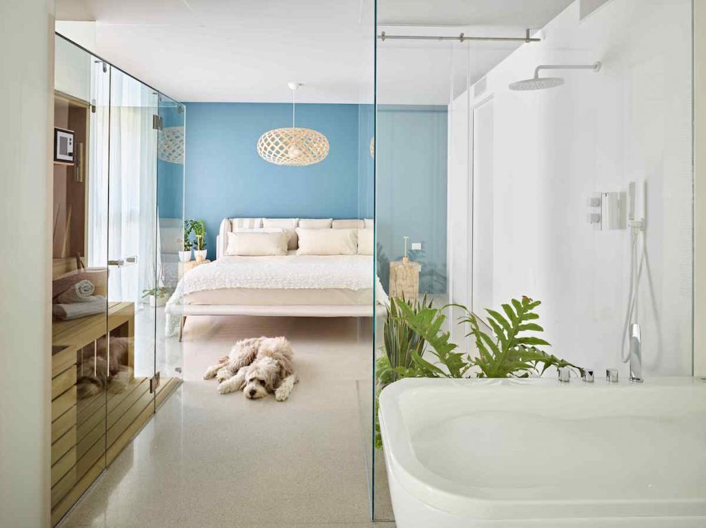 Útulná spálňa s modrou stenou a kúpeľňou