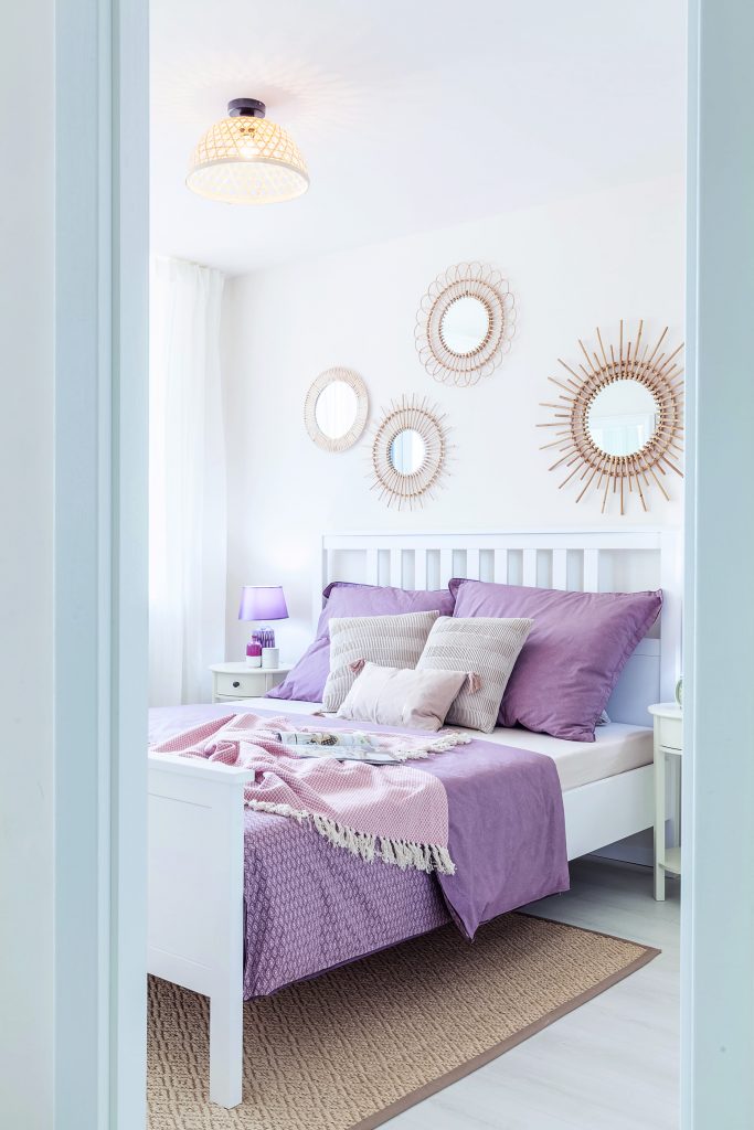 Spálňa s fialovými obliečkami a dekoráciami