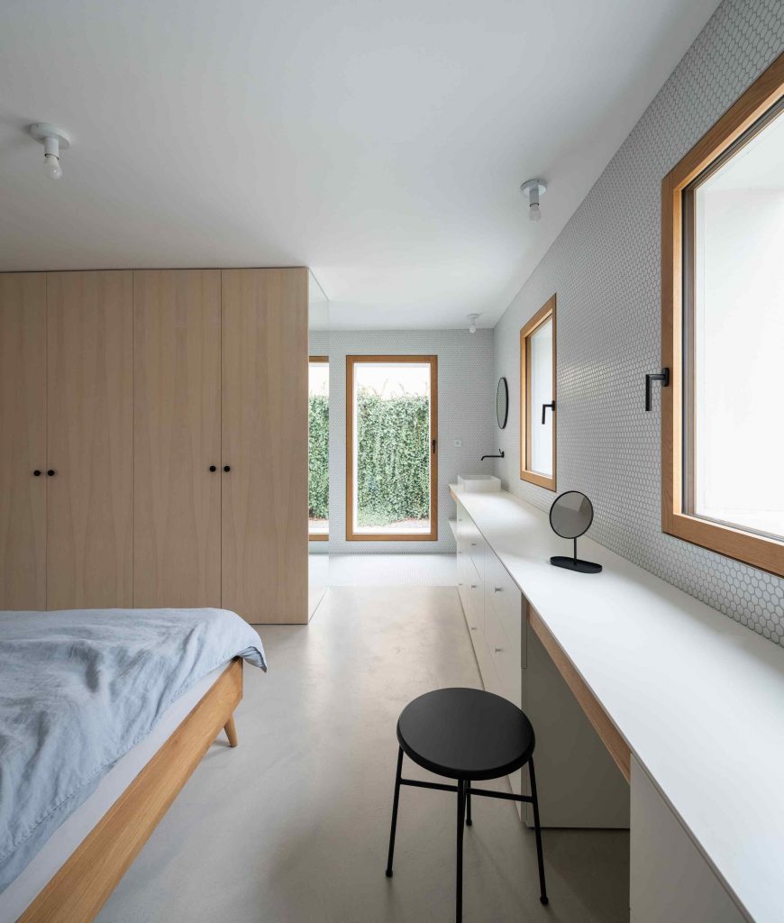 Minimalistická spálňa s oknami do záhrady a kúpeľňou