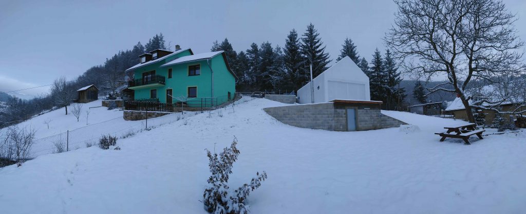 Celobiely dom v horách vo svahu v zime