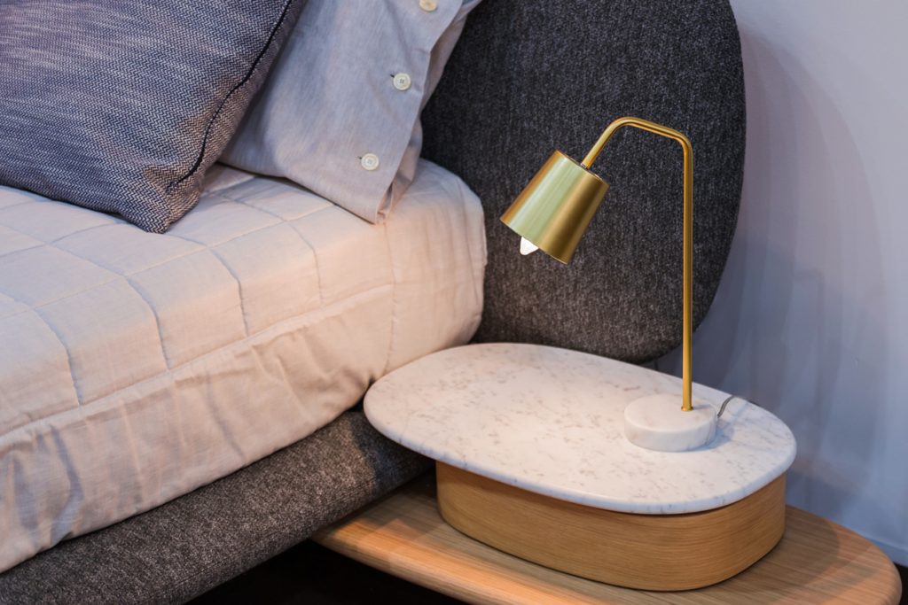Zlatá dizajnová lampa pri posteli