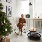 Vianočná obývačka v modernom byte so sediacou ženou