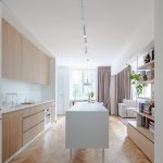 Moderná kuchyňa s parketovou podlahou a bielym ostrovčekom