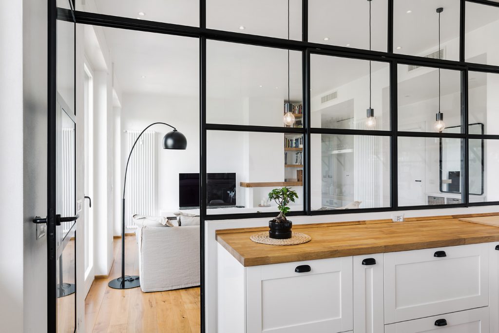 Čierna kovová konštrukcia deliaca kuchyňu od obývačky