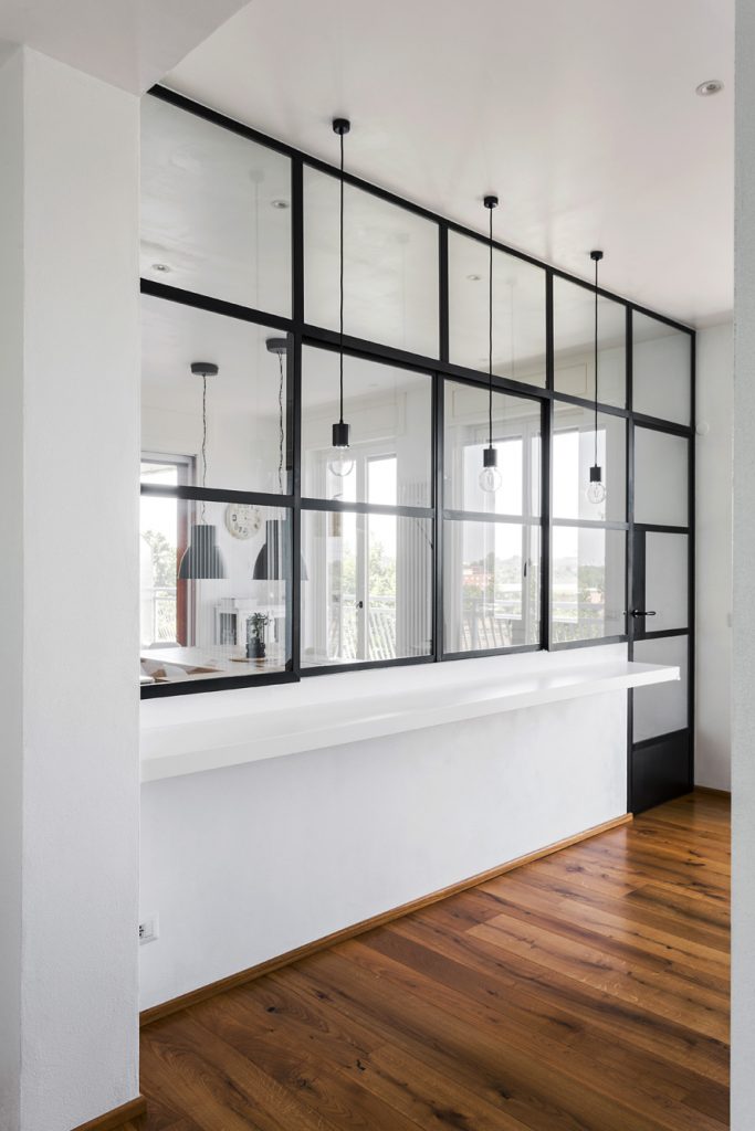 Čierna kovová konštrukcia deliaca kuchyňu od obývačky
