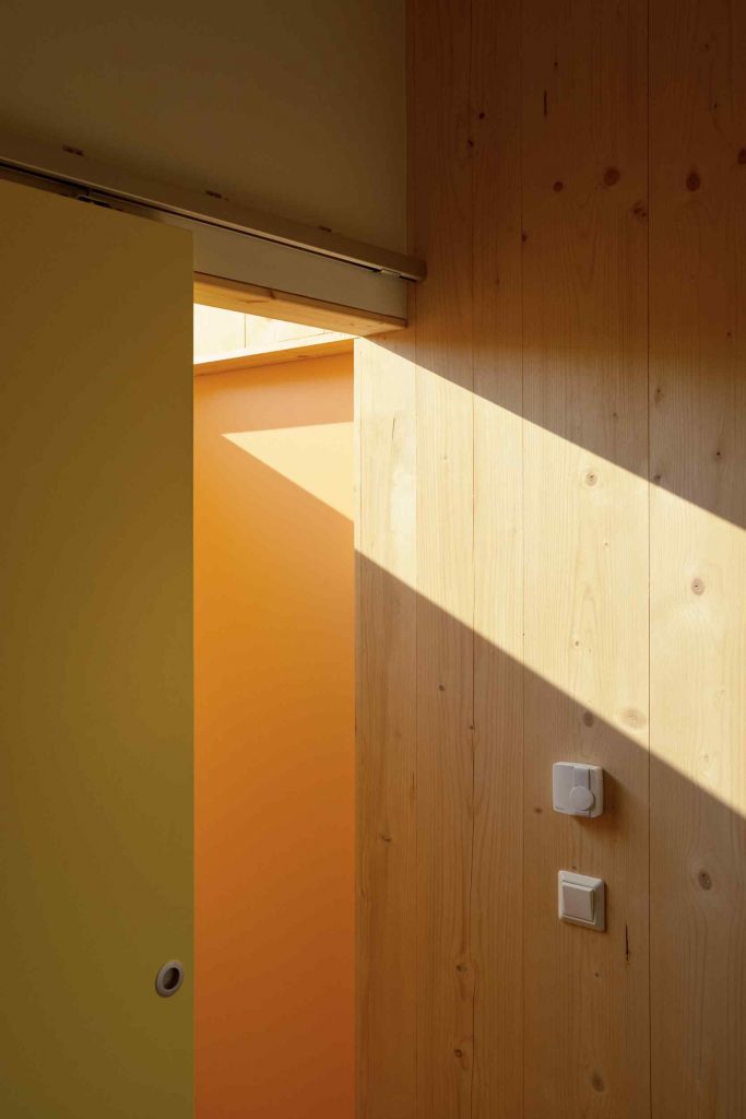 Farebné vnútorné posuvné dvere v drevenom interiéri