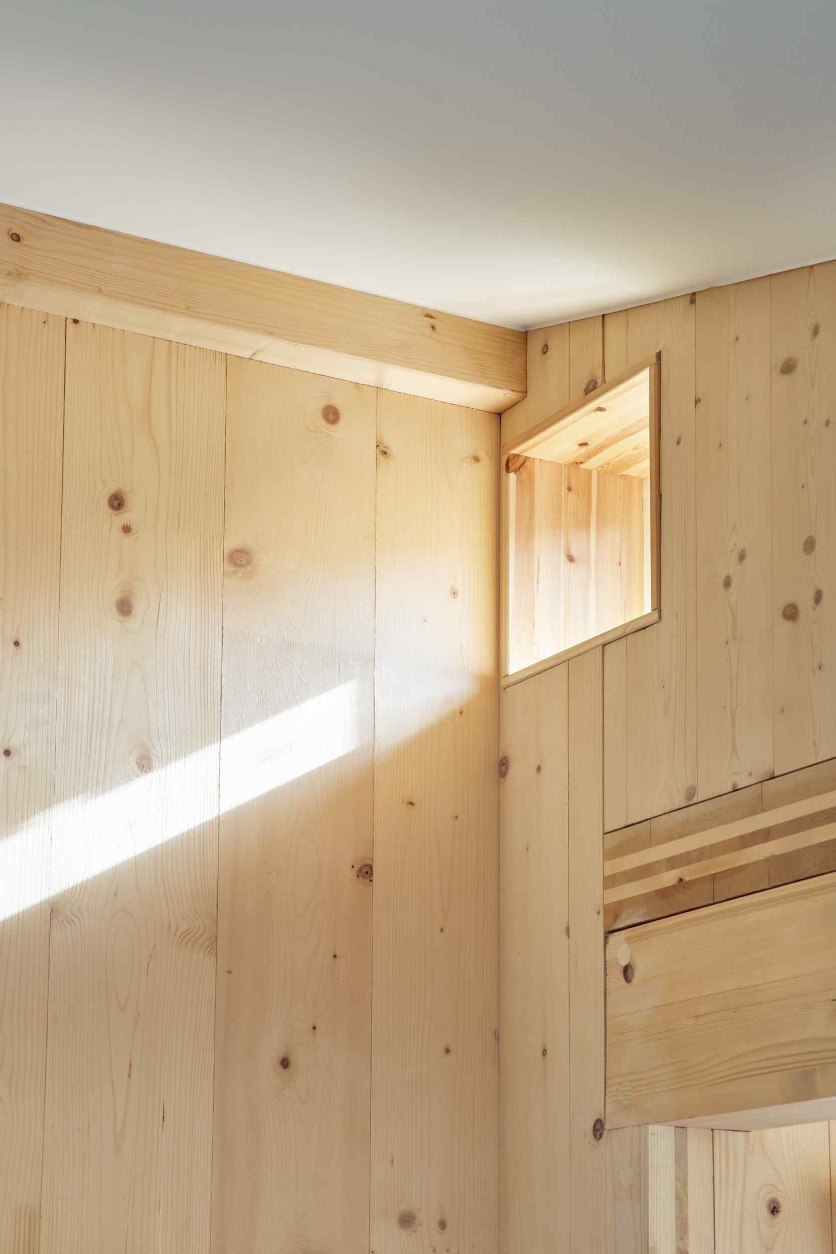 Drevené steny ponechali architekti odhalené a neošetrené, čo dáva domu určitú surovosť, pričom ho stále udržuje rafinovaný a teplý.