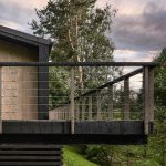 Víkendový dom v lese obkolesený terasou