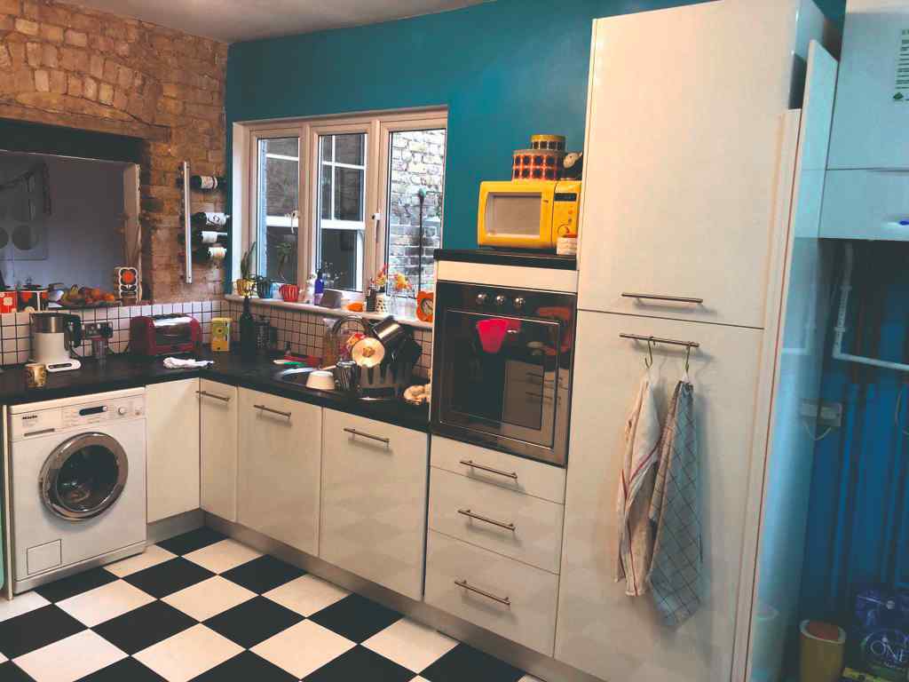 Pôvodná retro biela kuchyňa s čiernobielou dlažbou a modrou stenou