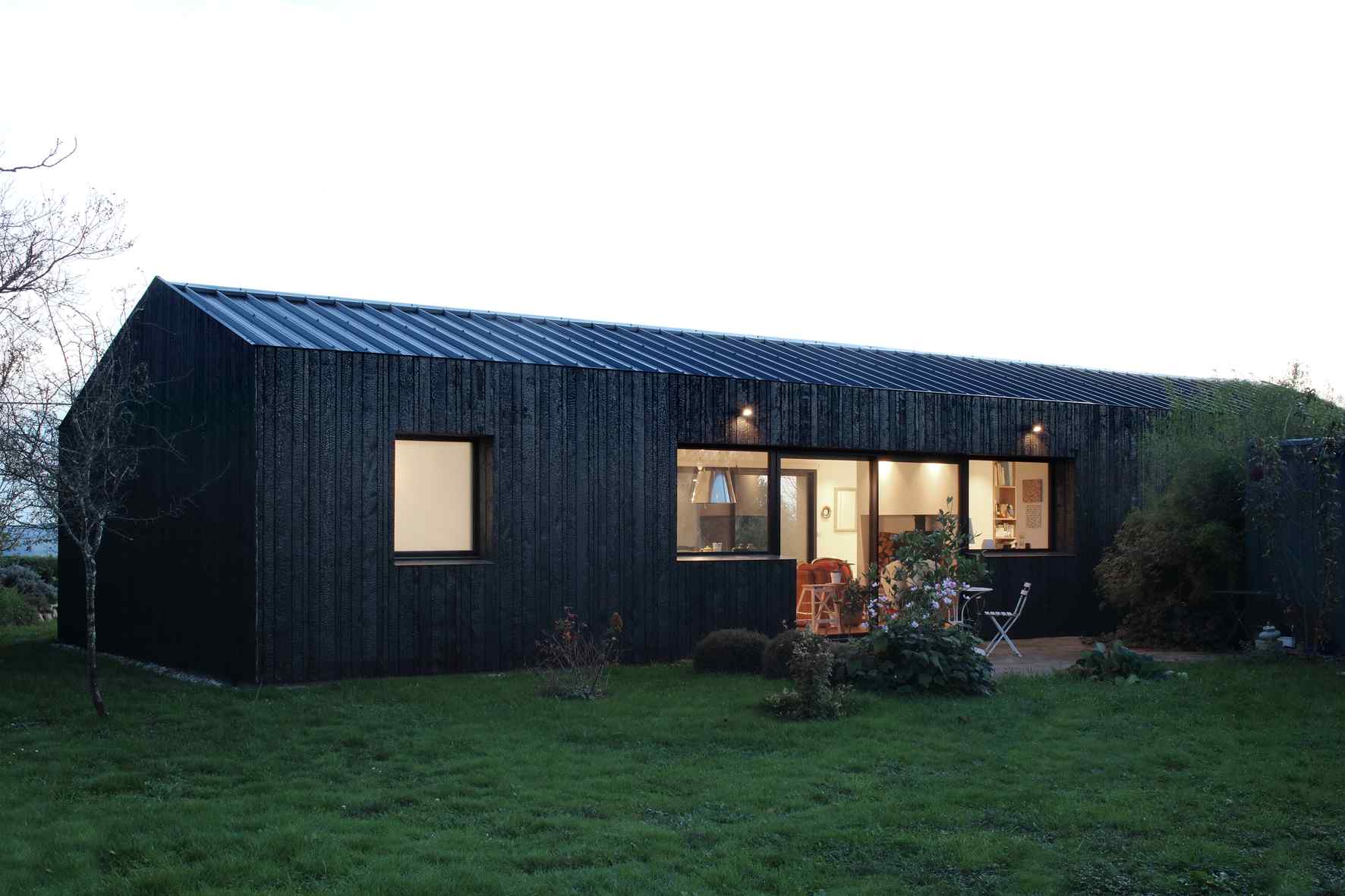 Menší prízemný dom z opáleného dreva s teraskou