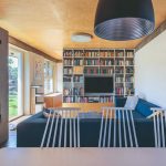 Obývačka s preglejkovým stropom modrým gaučom a krbom