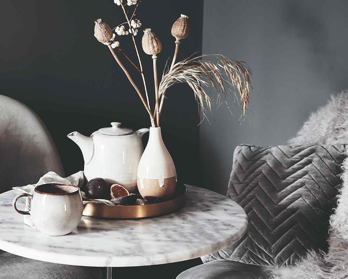 Mramorový stolík s čajníkom a vázou so slamenými kvetmi