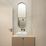 Kúpeľňa s malým umývadlom a oválnym zrkadlom