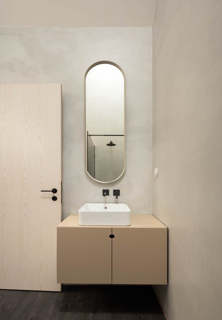 Kúpeľňa s malým umývadlom a oválnym zrkadlom