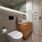 Kúpeľňa v sivej s drevenou skrinkou