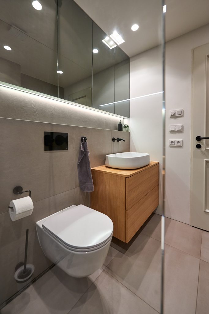 Kúpeľňa v sivej s drevenou skrinkou