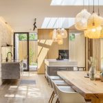Kuchyňa a jedáleň s kamennou stenou a dizajnovými svietidlami
