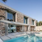 Stredomorská vila s kamennou fasádou bazénom a presklením