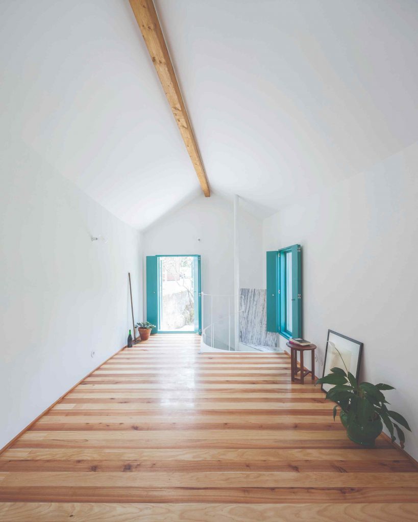 Biela miestnosť s pruhovanou podlahou a tyrkysovými oknami