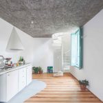 Kuchyňa s pruhovanou podlahou a s malým točitým schodiskom