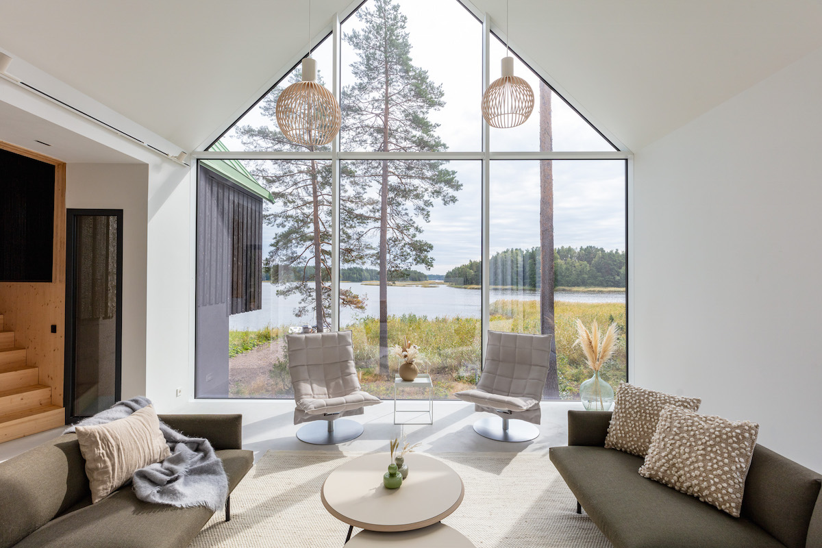 Biely interiér rodinného domu s presklenou fasádou s výhľadom na more