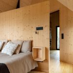 Spálňa v dome zo svetlého dreva s prírodnými textíliami