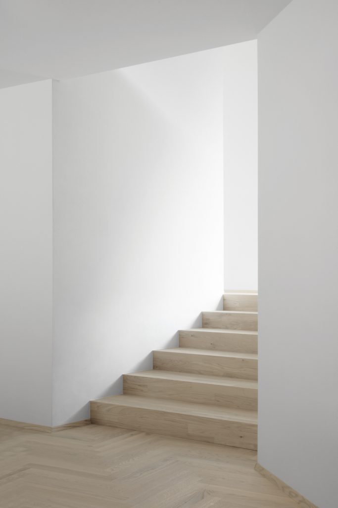 Drevené schodisko v bielom interiéri