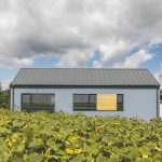 Jednoduchý sivomodrý pasívny dom so šikmou strechou