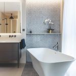 Kúpeľňa so sivou mozaikou a voľne stojacou vaňou