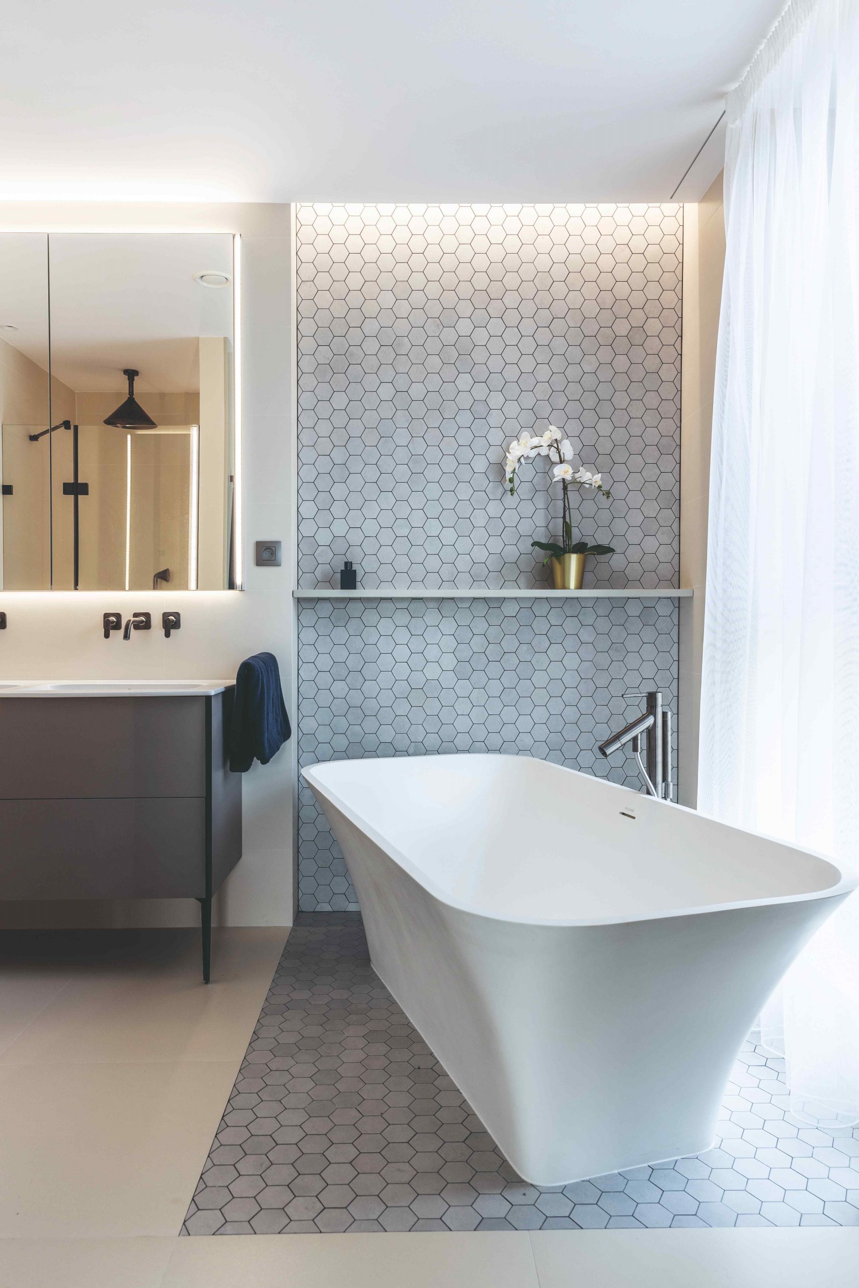 Kúpeľňa so sivou mozaikou a voľne stojacou vaňou