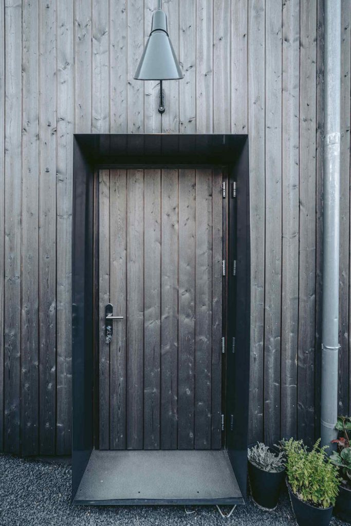 Vchodové dvere do domu s drevenou fasádou