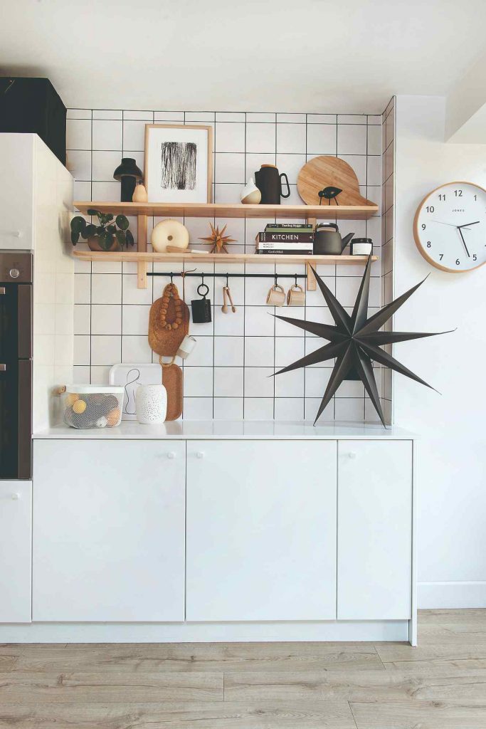 Malá kuchyňa v bielej s výraznou škárovačkou a prírodným náradím