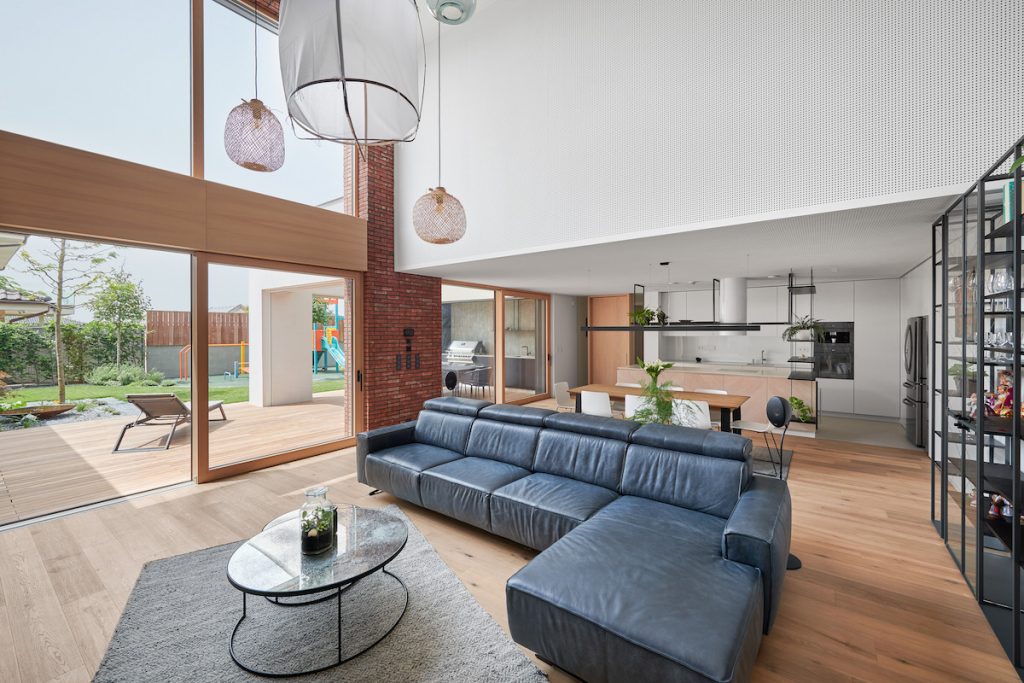 Veľká moderná dizajnová obývačka a kuchyňa v presklenom dome