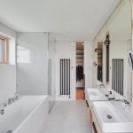 Biela kúpeľňa s dvoma umývadlami a šatníkom