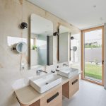 Biela kúpeľňa s dvoma umývadlami a mramorovou stenou