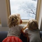 Deti pozeraju cez strešné okno na stromy