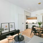 Malý byt s parketami sivočiernym nábytkom a kuchynkou